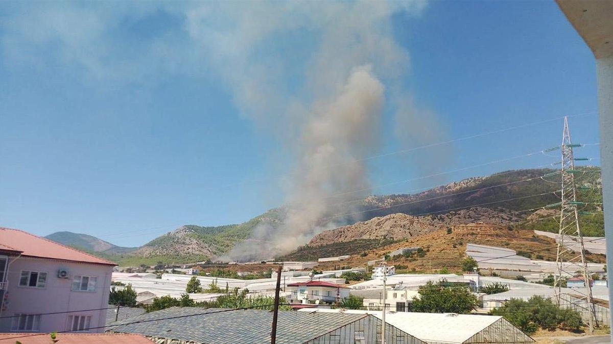 A firefighting helicopter dropping water over a forest fire in Mersin, Turkey