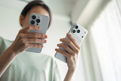 Smartphone in a user's hands against the background of system settings
